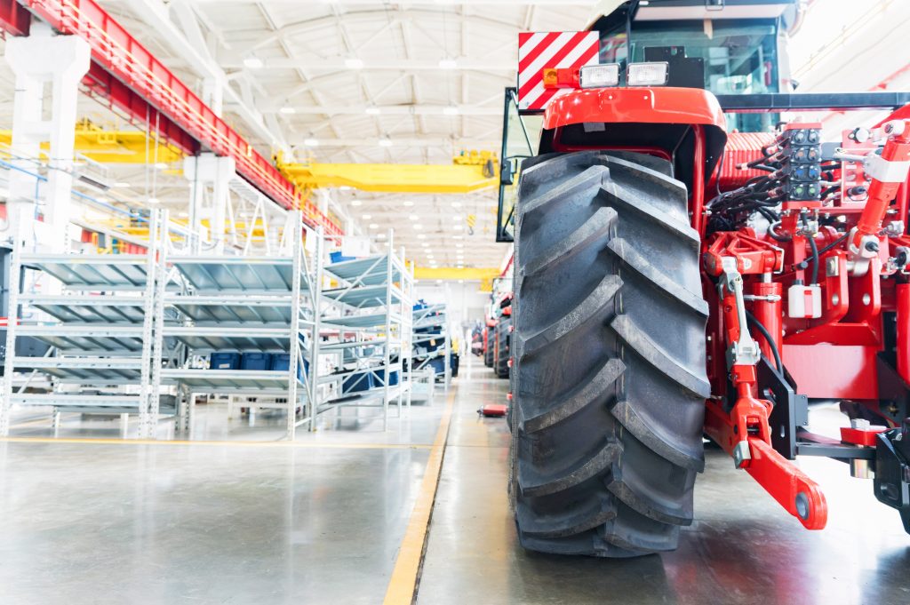 blurred assembly workshop and tractor wheel at big industrial plant